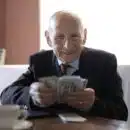 un senior avec des billets à la main