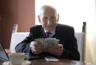 un senior avec des billets à la main