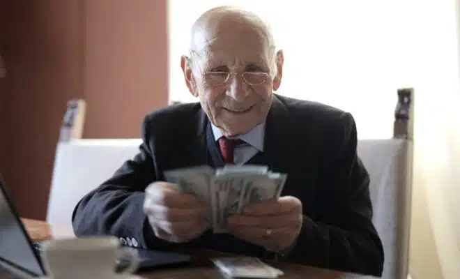 un senior avec des billets à la main